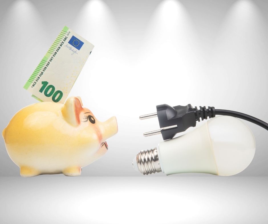 Sparschwein mit 100-Euro-Schein und Stromstecker als Symbol für Stromkosten, Jahresabrechnung und Einsparpotenziale